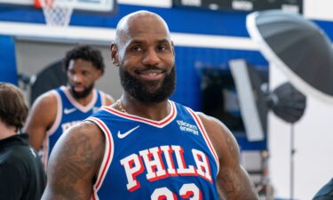 Philadelphia 76ers' LeBron James reacts as he goes between stations during the NBA basketball team's media day in Camden