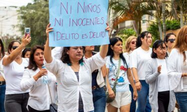 Residents and parents gather outside the Liceo Naval Almirante Guise school in San Borja