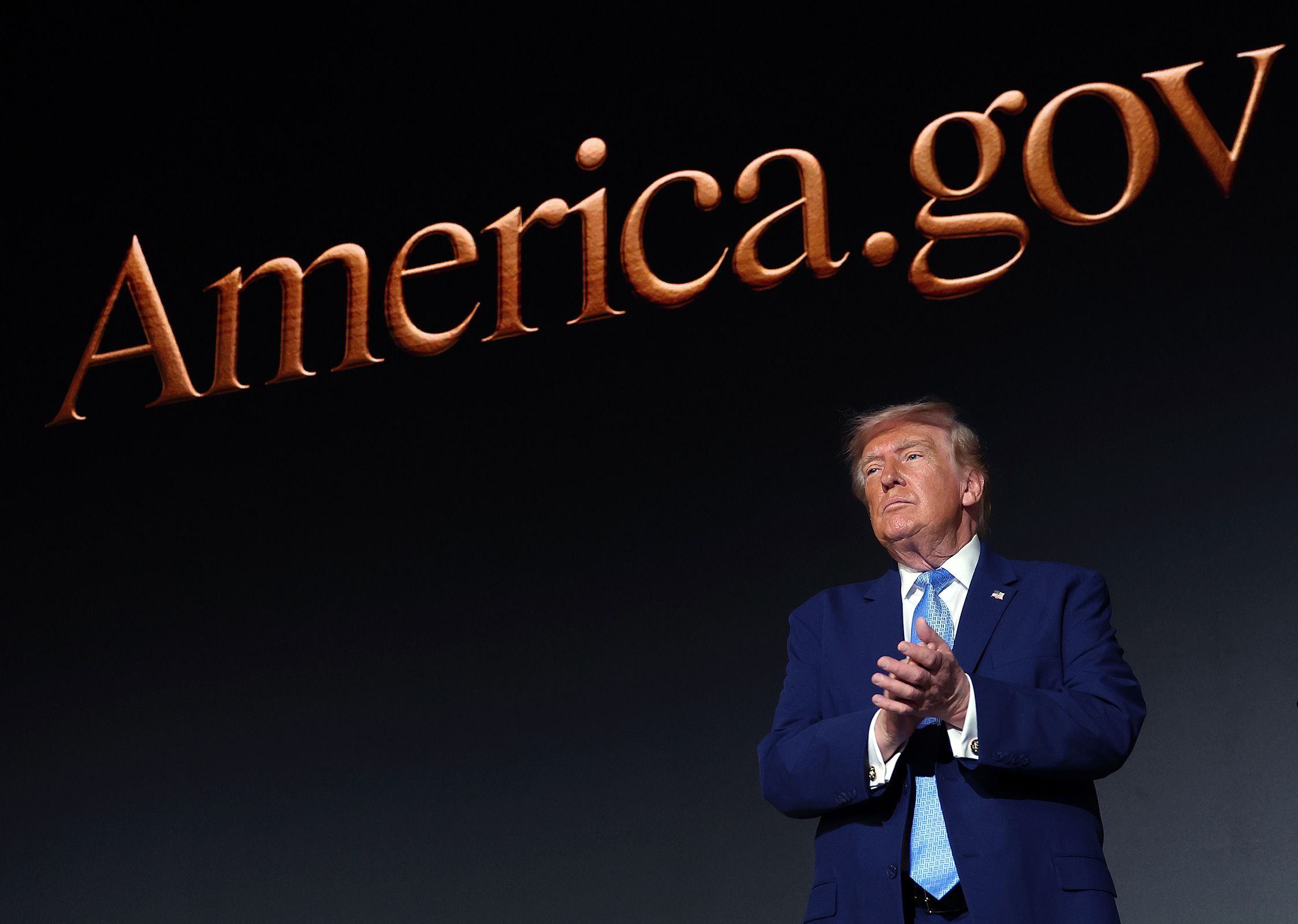 <i>Kevin Dietsch/Getty Images via CNN Newsource</i><br/>President Donald Trump applauds on stage during the America.gov launch event at Andrew W. Mellon Auditorium in Washington