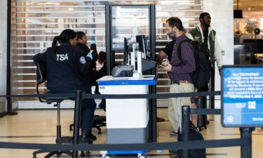 Transportation Security Administration agents sit as they check boarding passes and IDs at Ronald Reagan Washington National Airport