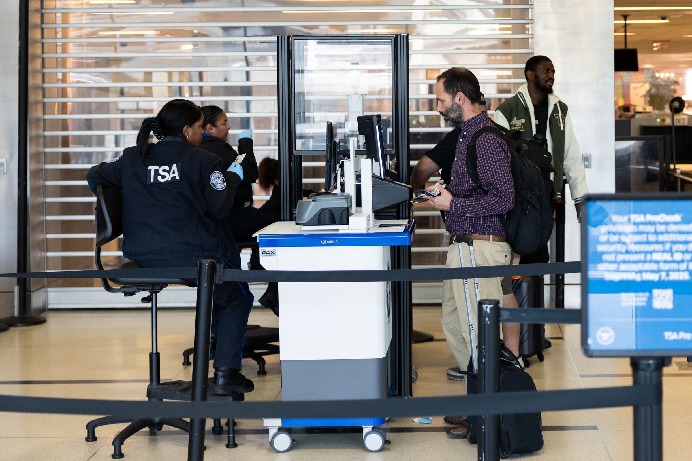 <i>Valerie Plesch/Bloomberg/Getty Images via CNN Newsource</i><br/>Transportation Security Administration agents sit as they check boarding passes and IDs at Ronald Reagan Washington National Airport