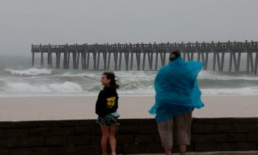 Gina Holland evacuates her home with her dog Cici in Pensacola on Friday.