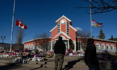 People pay their respects at a memorial on the steps of the Town Hall