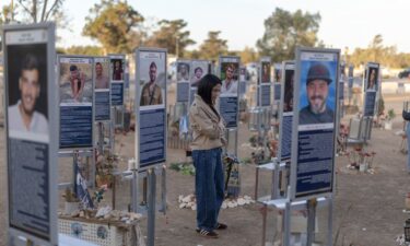 An Israeli woman pays her respects at a memorial to the victims of the 2023 Hamas attacks at the Nova festival site in Reim