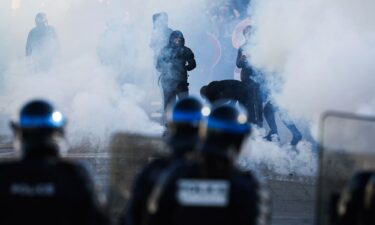 Firefighters extinguish a fire at the entrance of the Leonard de Vinci secondary school in Paris following a protest on Friday.