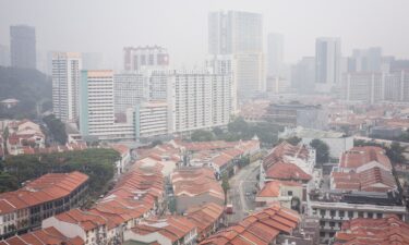 Pedestrians walk across a road as buildings are seen shrouded by haze in Singapore on October 9. Indonesia has been battling fires for weeks in parts of Borneo and Sumatra