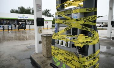 Workers cordon off a gas pump with yellow tape at a gas station in Navarre