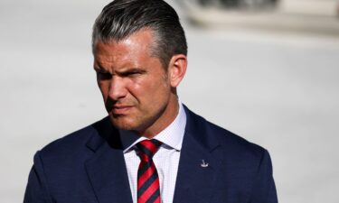Secretary of Defense Pete Hegseth looks on as President Donald Trump speaks to the news media