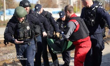 A paramedic and police officers carry a person injured at a railway station during a Russian drone strike