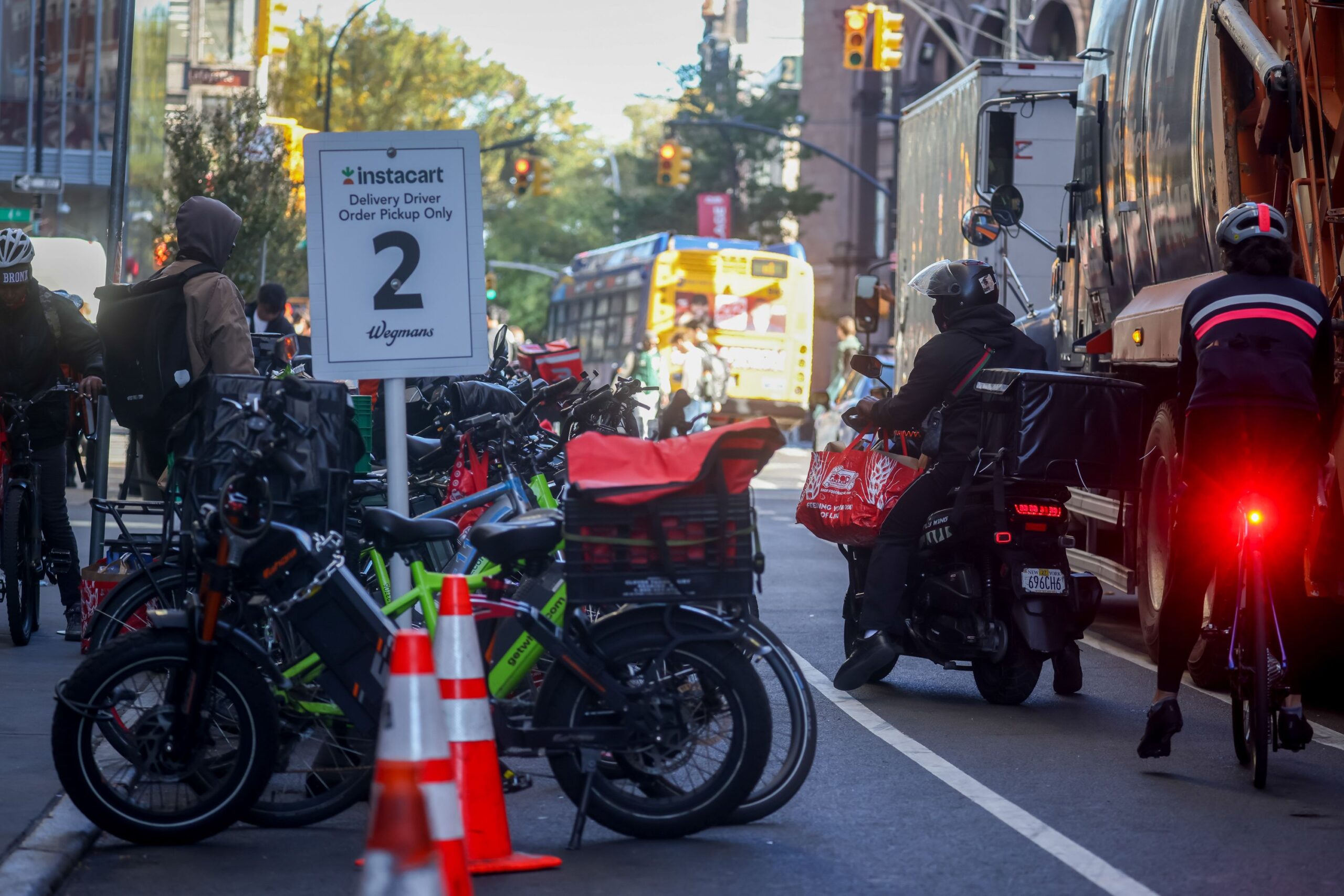 <i>Michael Nagle/Bloomberg/Getty Images via CNN Newsource</i><br/>Delivery workers pick up orders outside a grocery store in New York on Tuesday.