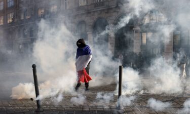 Protesters inside a bar face riot mobile gendarmes near Porte de Vincennes during a demonstration in Paris