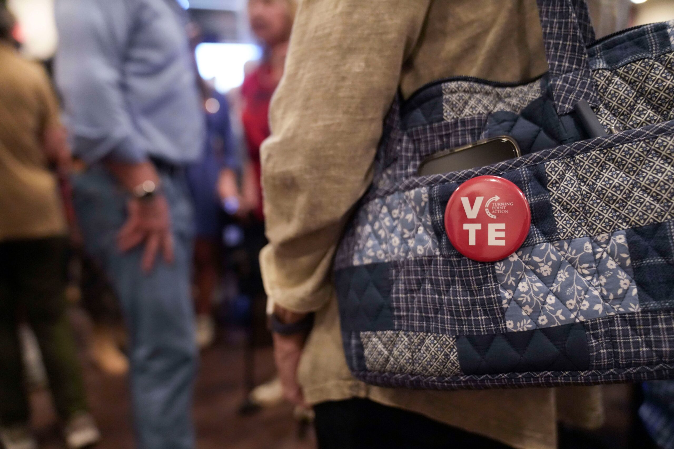 <i>Megan Varner/Getty Images via CNN Newsource</i><br/>A woman wears a Turning Point Action pin on her bag on October 12