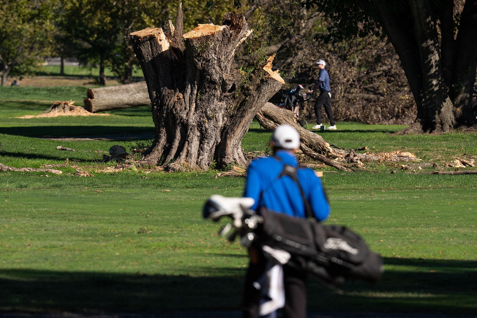 <i>Aaron Schwartz/Bloomberg/Getty Images via CNN Newsource</i><br/>Golfers play past felled trees at East Potomac Golf Links in Washington D.C.