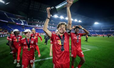 Mehmeti celebrates with teammates in an MLS match.