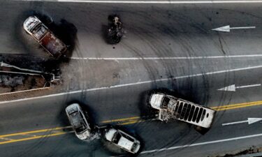 This aerial view shows burned cars and trucks