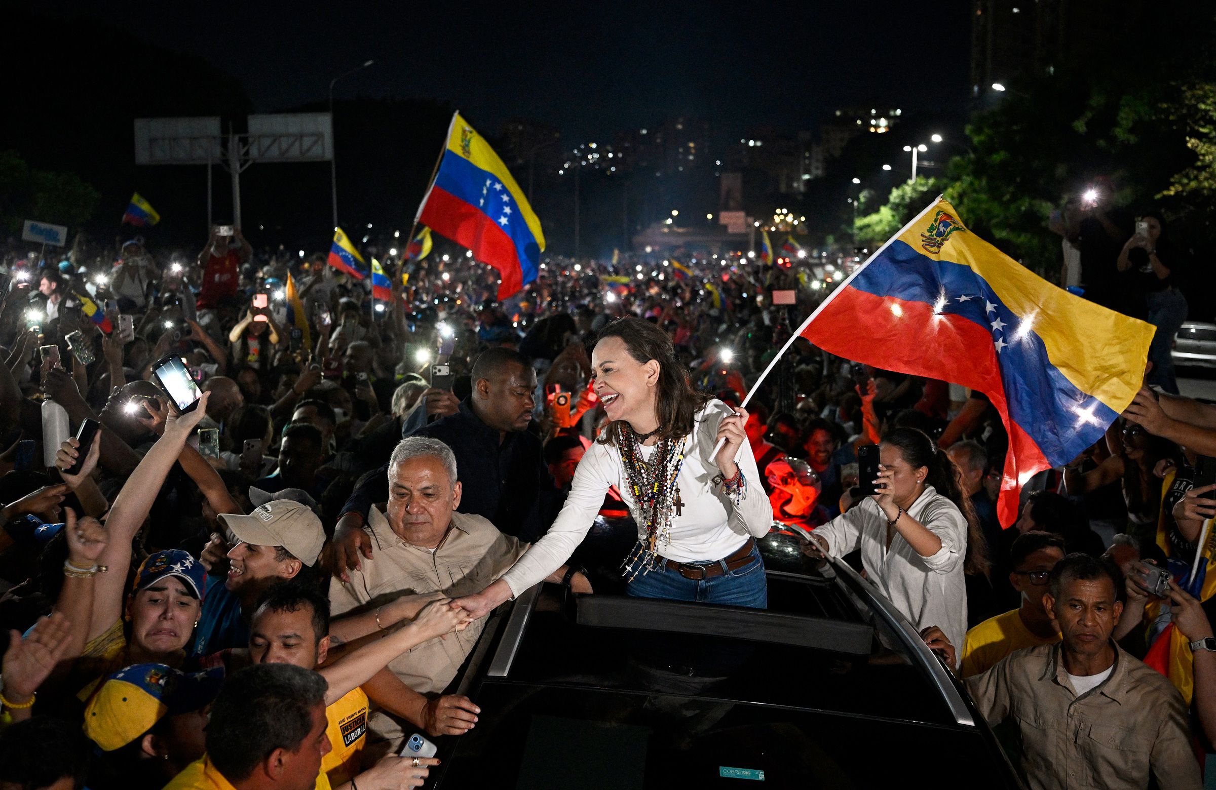 <i>Federico Parra/AFP/Getty Images via CNN Newsource</i><br/>Venezuelan opposition leader and Nobel Peace Prize laureate Maria Corina Machado greets supporters upon her arrival in Caracas on October 25. Machado returned to her home country on October 25
