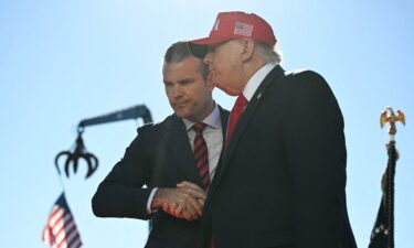 US President Donald Trump (R) shakes hands with Secretary of Defense Pete Hegseth as he arrives to speak at Anduril Industries in Sparrows Point
